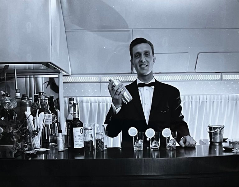 Item #227248 1960s Glossy Black and White Photo of a Bartender in a Lufthansa Airliner First Class Bar Lounge. Lufthansa Airlines.