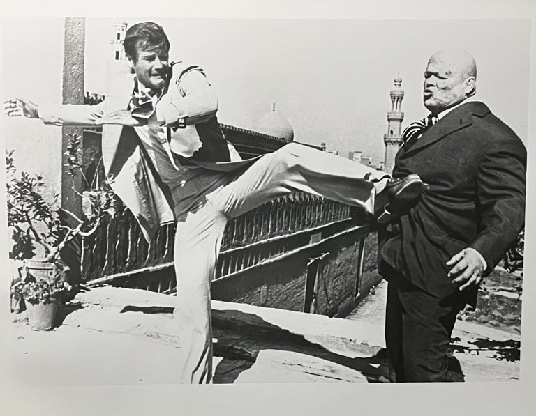 Item #531245 Black and White Press Photo for the 1974 Film Adaptation of Ian Fleming's The Man with the Golden Gun. Director Gus Hamilton, Richard Malbaum, Screenwriters Tom Mankiewicz.